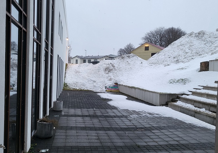Mynd af porti á bak við Amtsbókasafnið, snjór í kringum stéttina