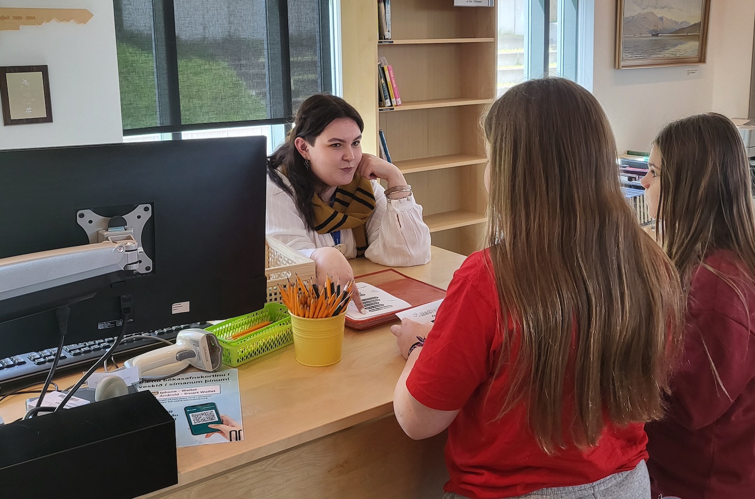 Woman by a desk helping kids solving puzzles