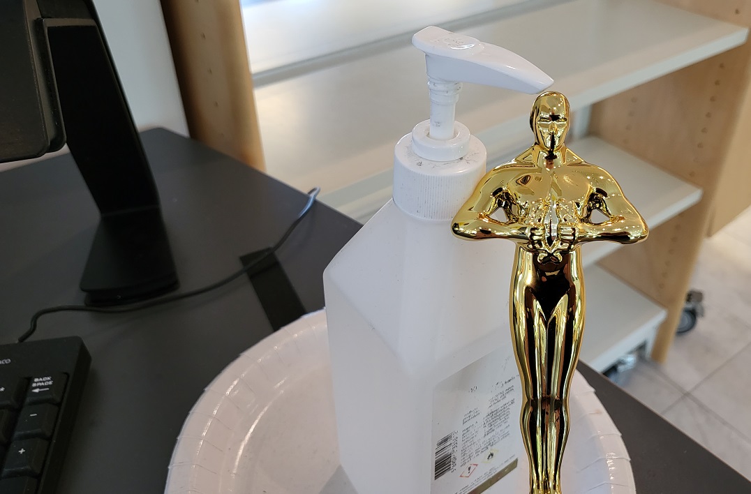 Mynd af Óskarsstyttu við sprittbrúsa