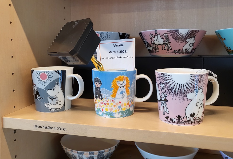 Mynd af Óskarsstyttu á hvolfi í múmínbolla sem er innan um aðra múmínbolla í hillu