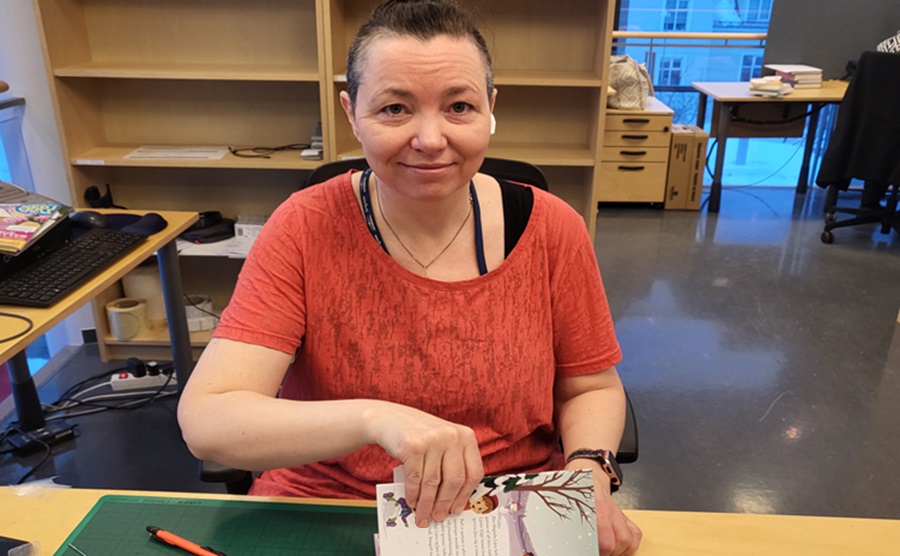 Library worker Dóra plasting a book
