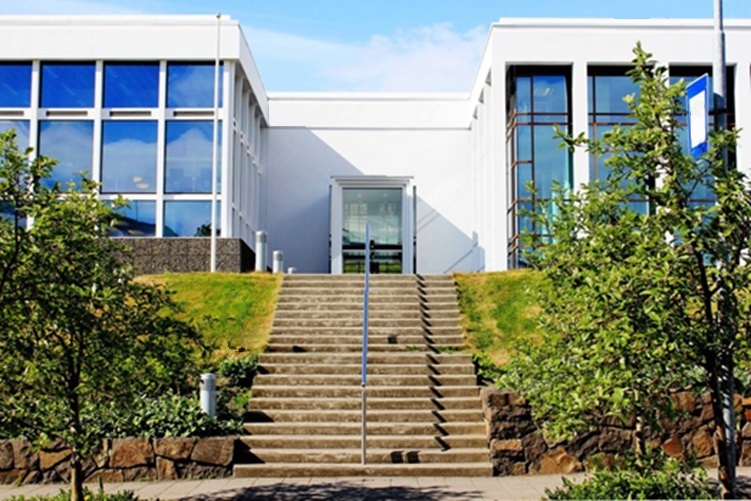 Picture of the Municipal Library, with clear skies and green grass and trees in front