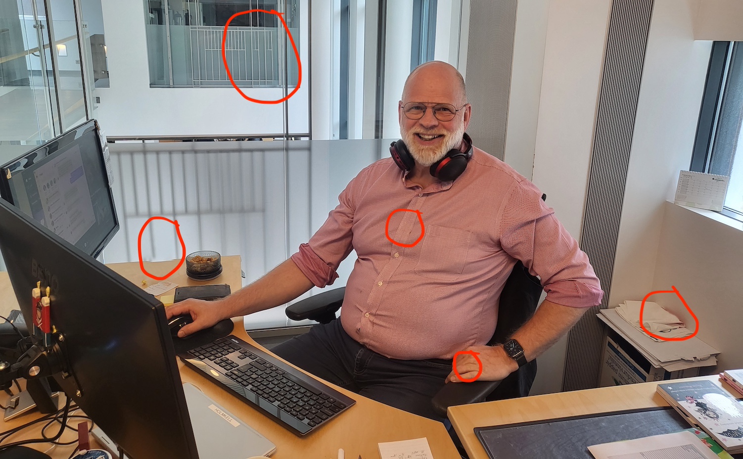 Man behind a desk in front of a computer and two screens