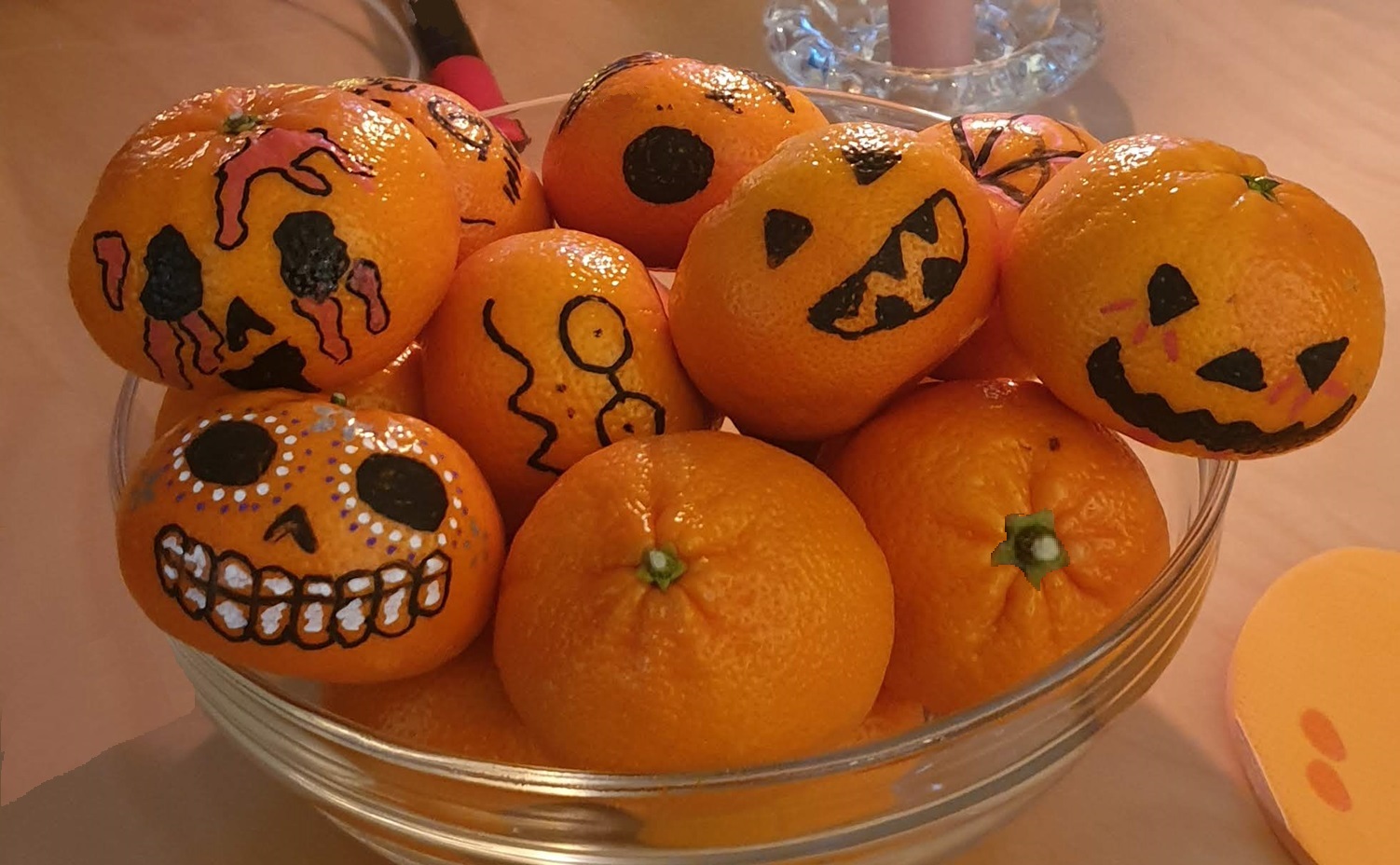 Picture of mandarines in a bowl, they are painted like small pumpkins