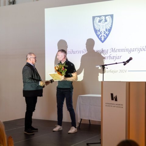 Heimir Örn Árnason formaður bæjarráðs veitir Þorsteini E. Arnórssyni heiðursviðurkenningu Menningarsjóðs Akureyrarbæjar.